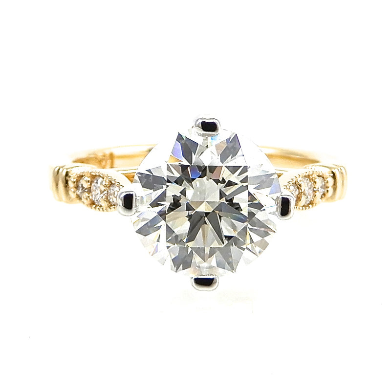 Round Diamond prong set with gold band accented with diamonds and milgrain detail 