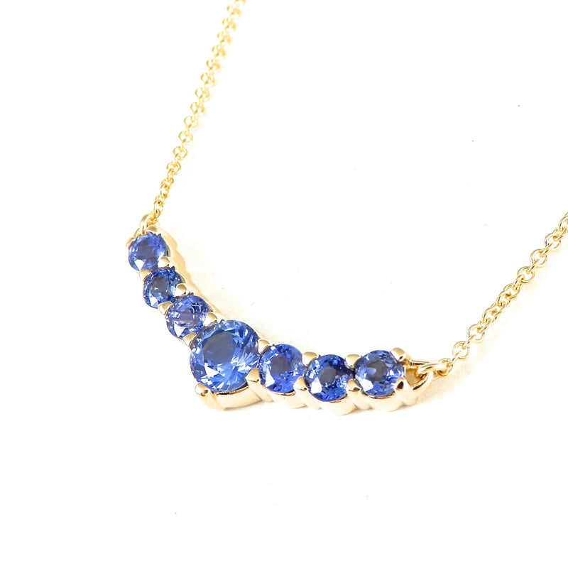 Tapered in size seven round blue sapphire stationary pendant necklace