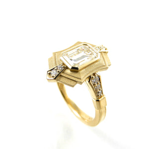 art deco inspired design with a bezel set center stone and diamond accents