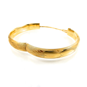 14k yellow-gold hinged bangle featuring a decorative finish with a heart motif