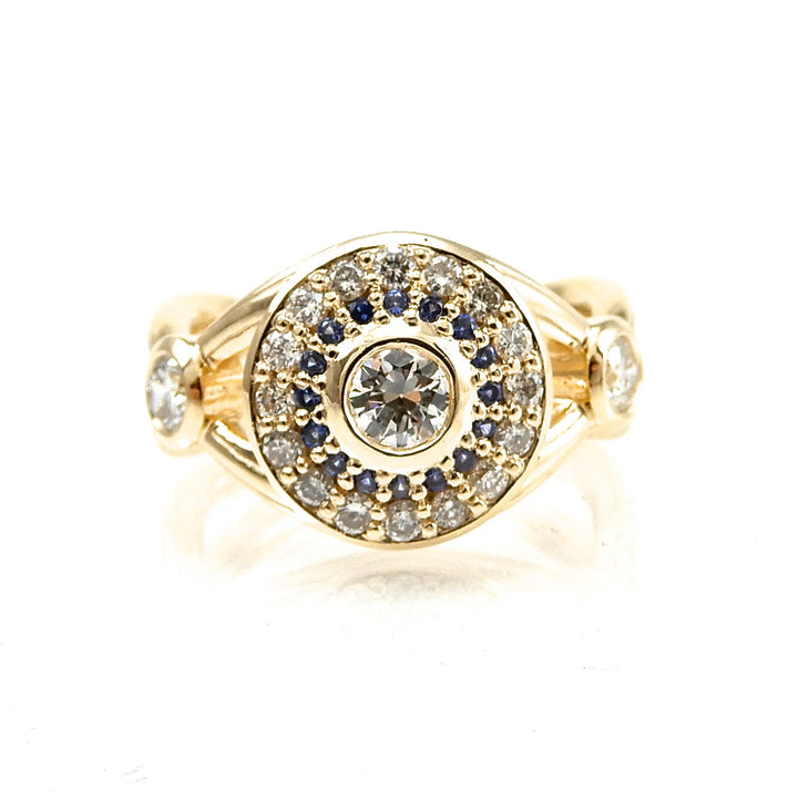 Bezel set diamond engagement ring with double halo of sapphires and round brilliant diamonds
