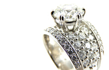 Load image into Gallery viewer, close up of round brilliant cut diamond center stone ring with a pave diamond accented shank and diamond borders