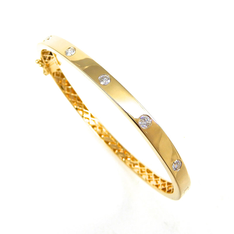 round diamonds flush set in a high shine yellow gold bangle 